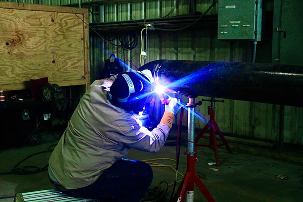 A TIG welding arc lighting up the pipe shop